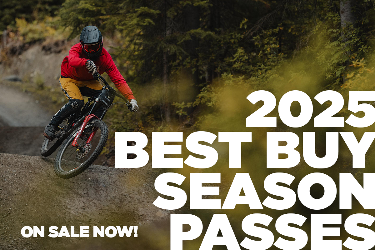 Mountain biker in red jacket rides on a forest trail.