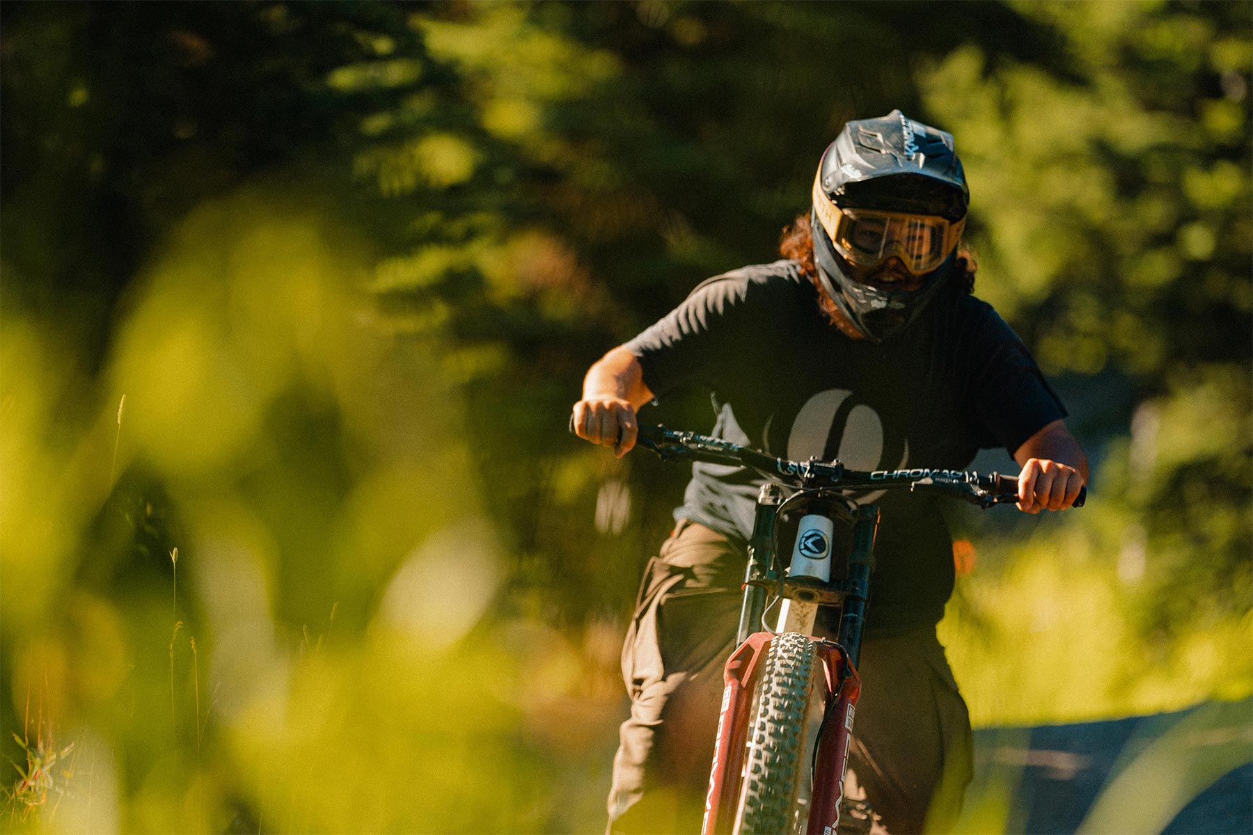 Biker riding in the sunshine with greenery around him