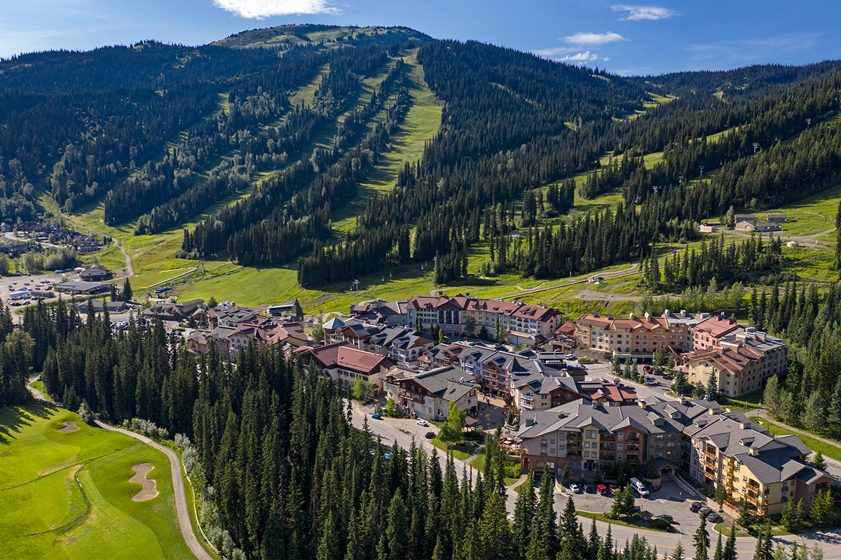 Sun Peaks village surrounded by green mountains in summer.