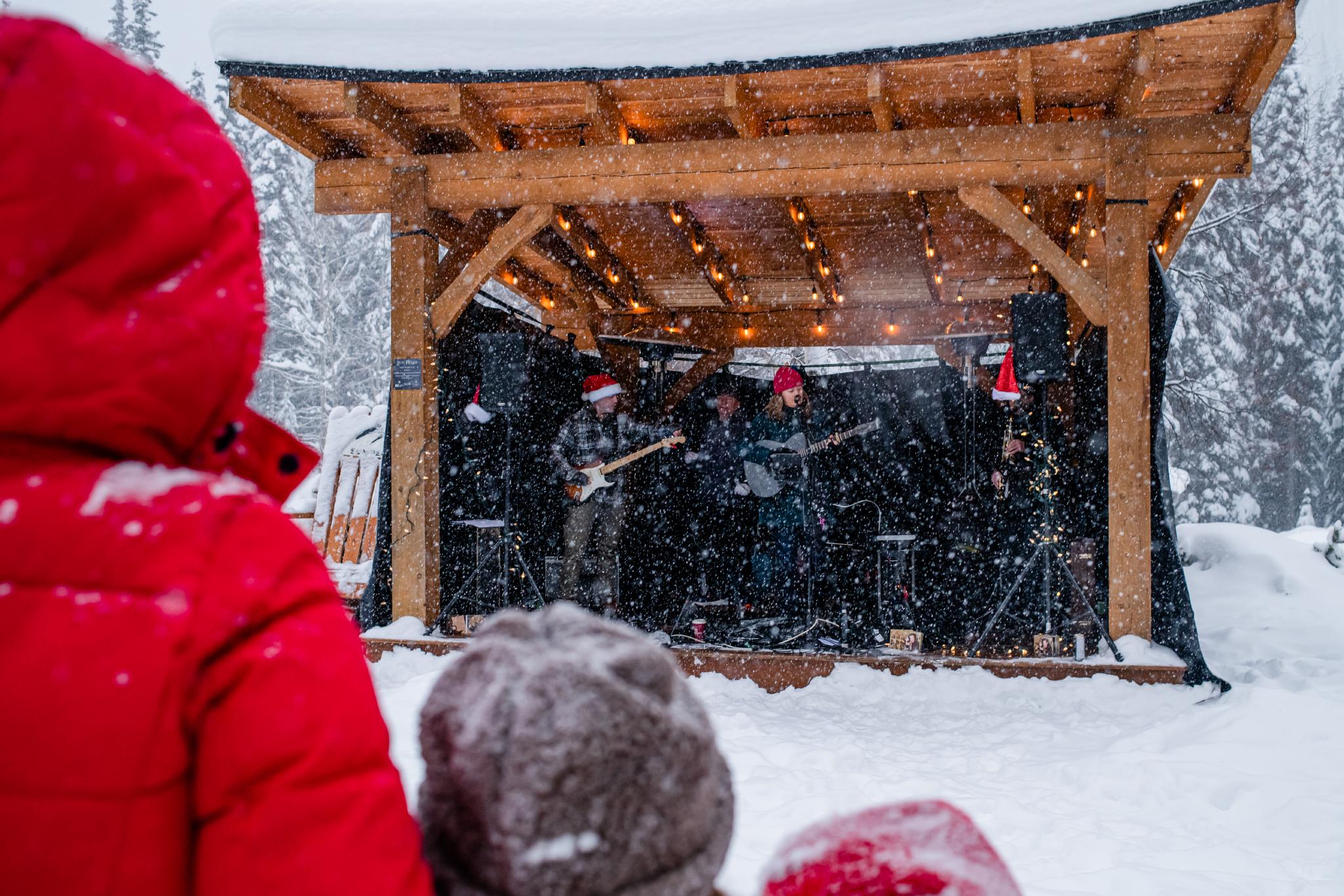 Band playing in Sun Peaks with Santa hats on while snow is falling