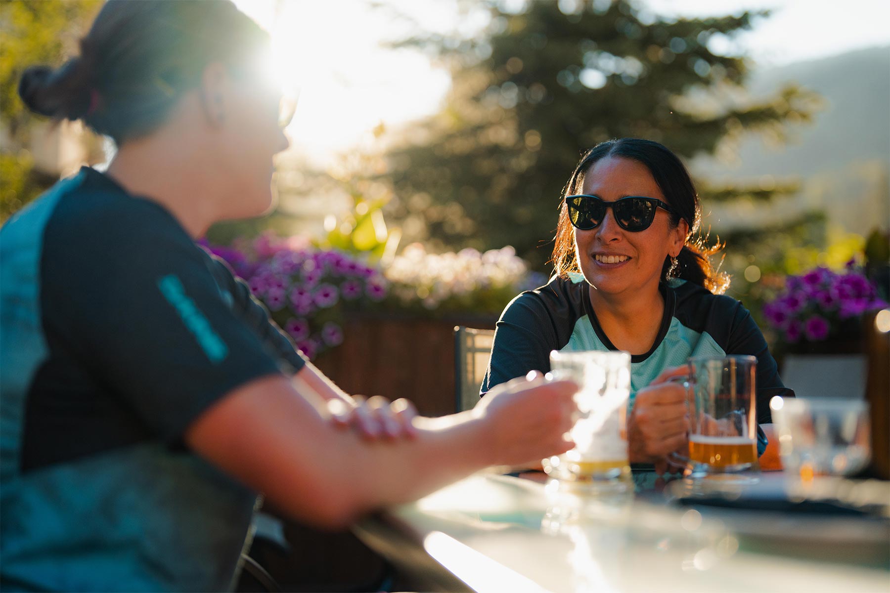 Two girls smiling on an outside patio in the sun