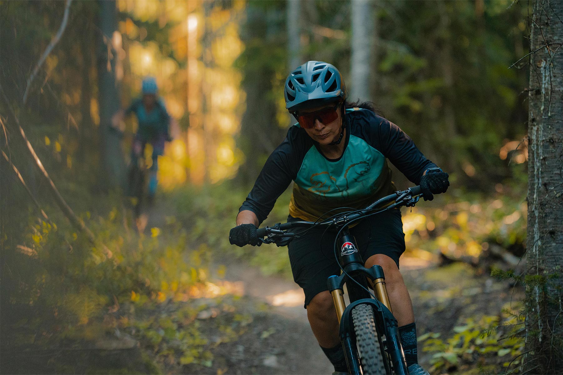 Women riding a bike standing up with trees around her