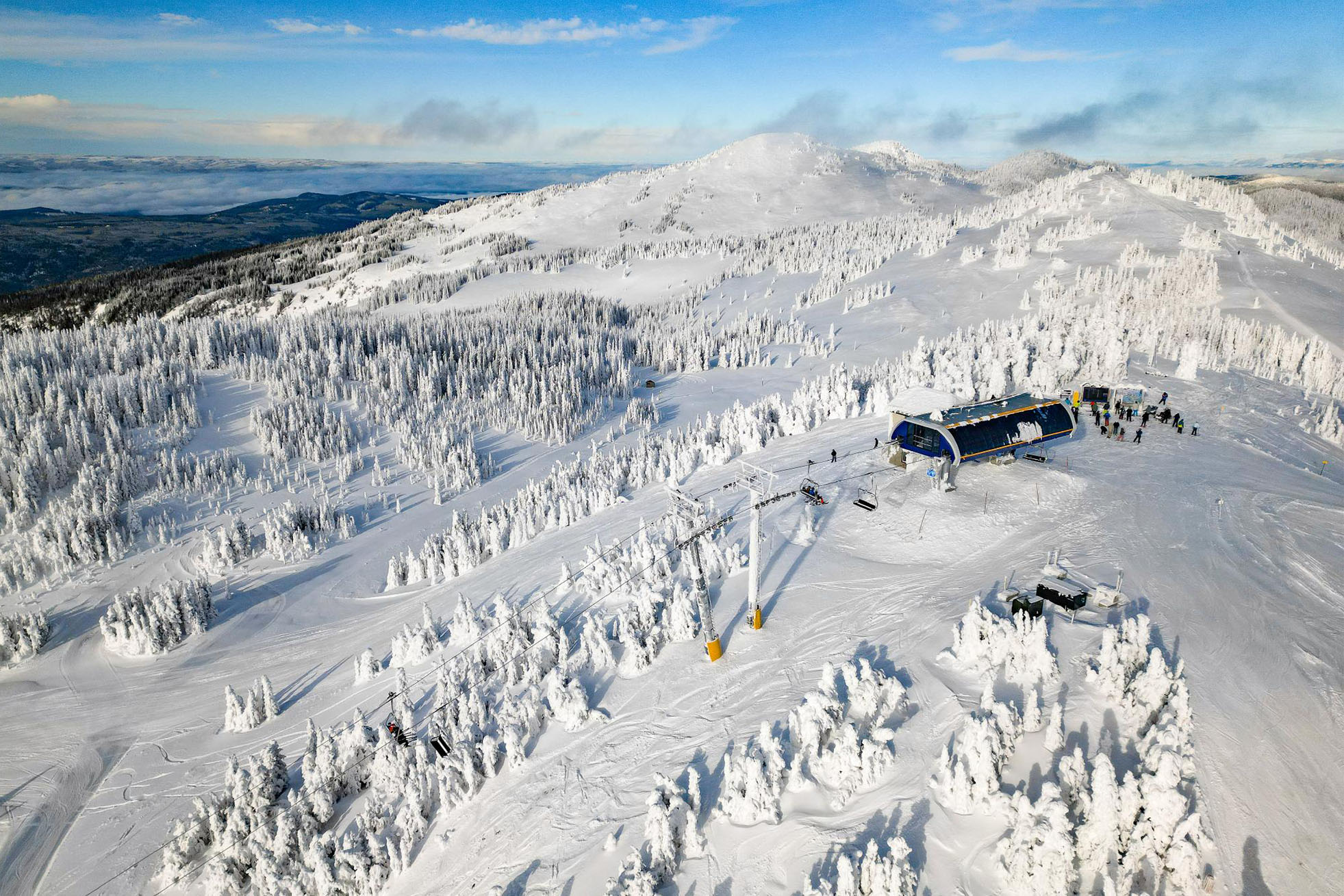 West Bowl and new West Bowl Express chairlift on a blue sky day with wispy clouds.