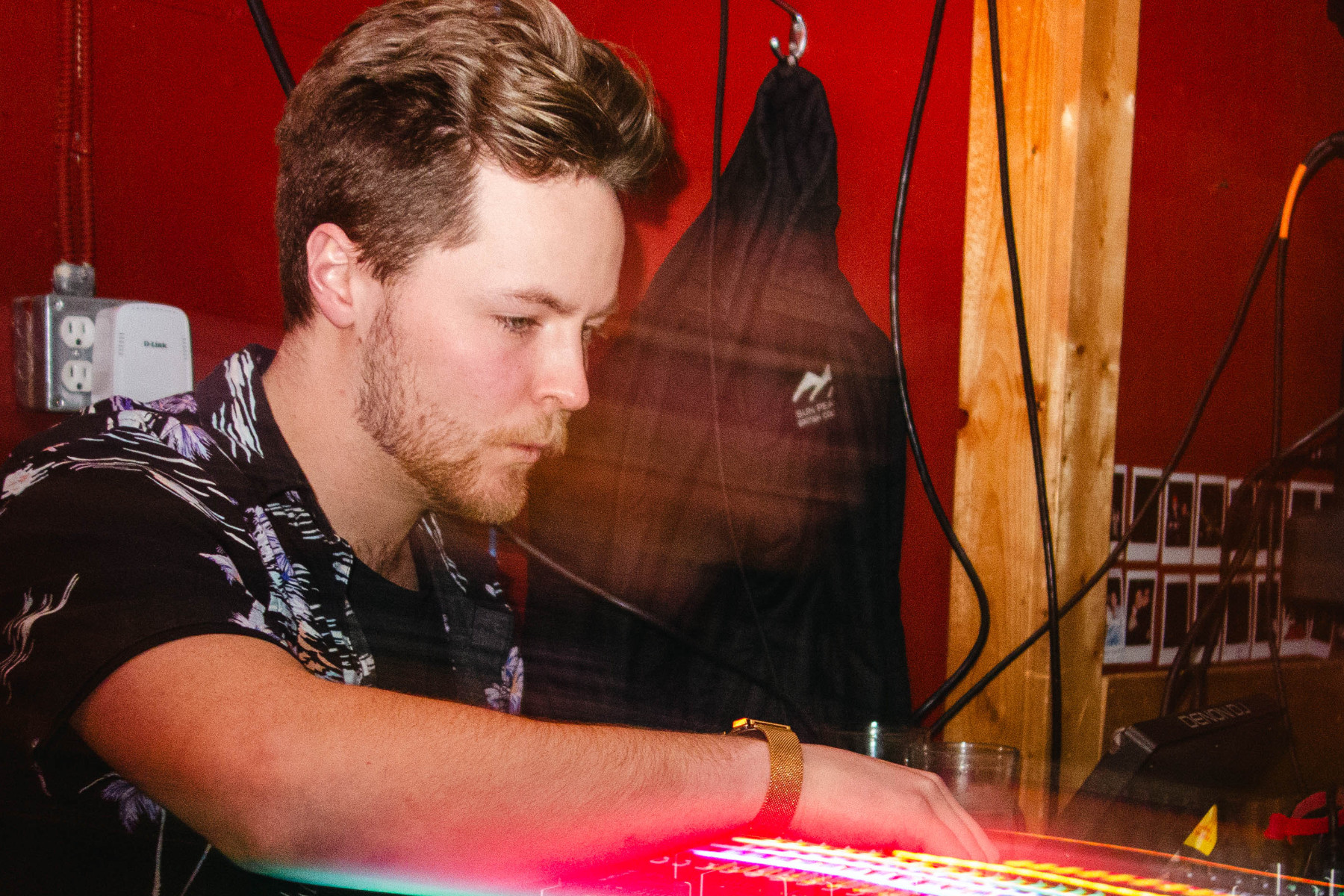 DJ playing music with red lights around him
