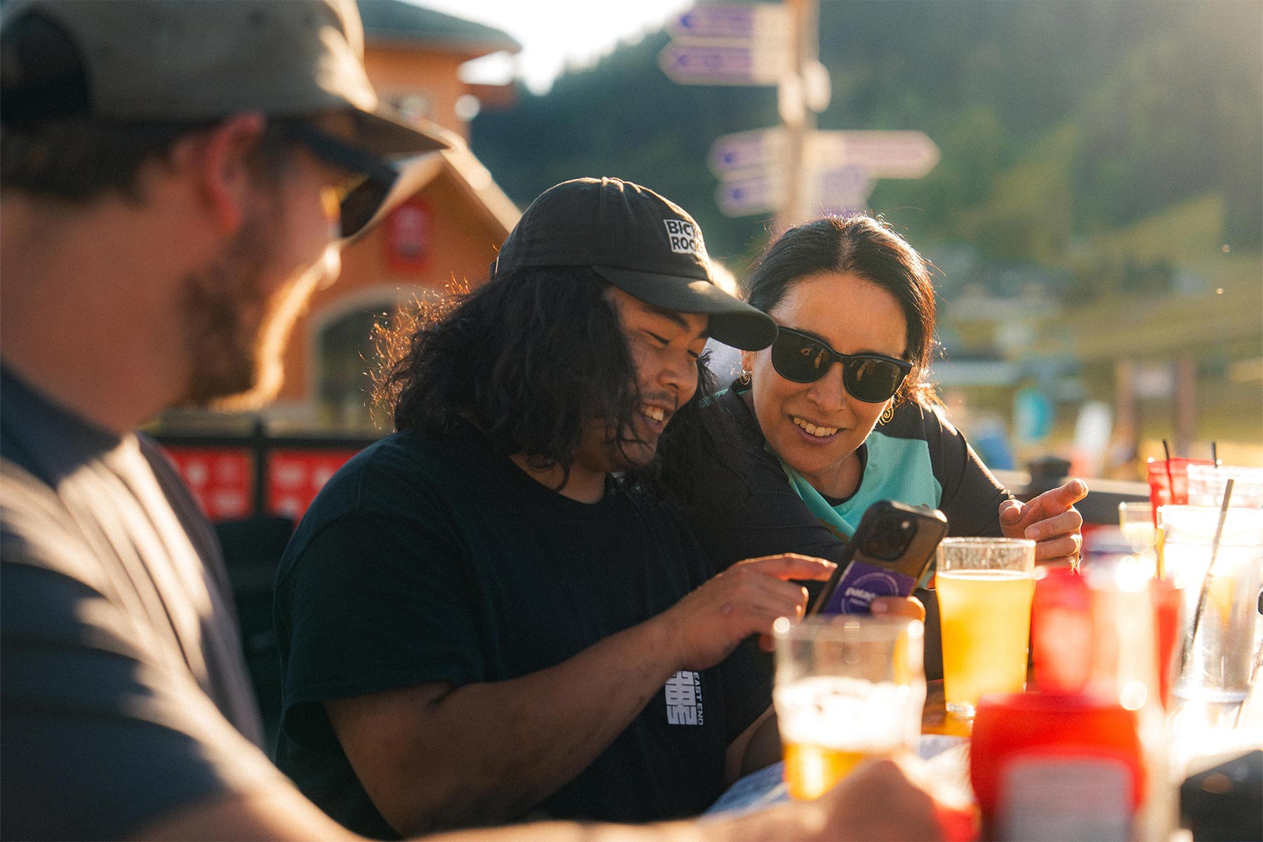 three people sitting in the sunshine laughing