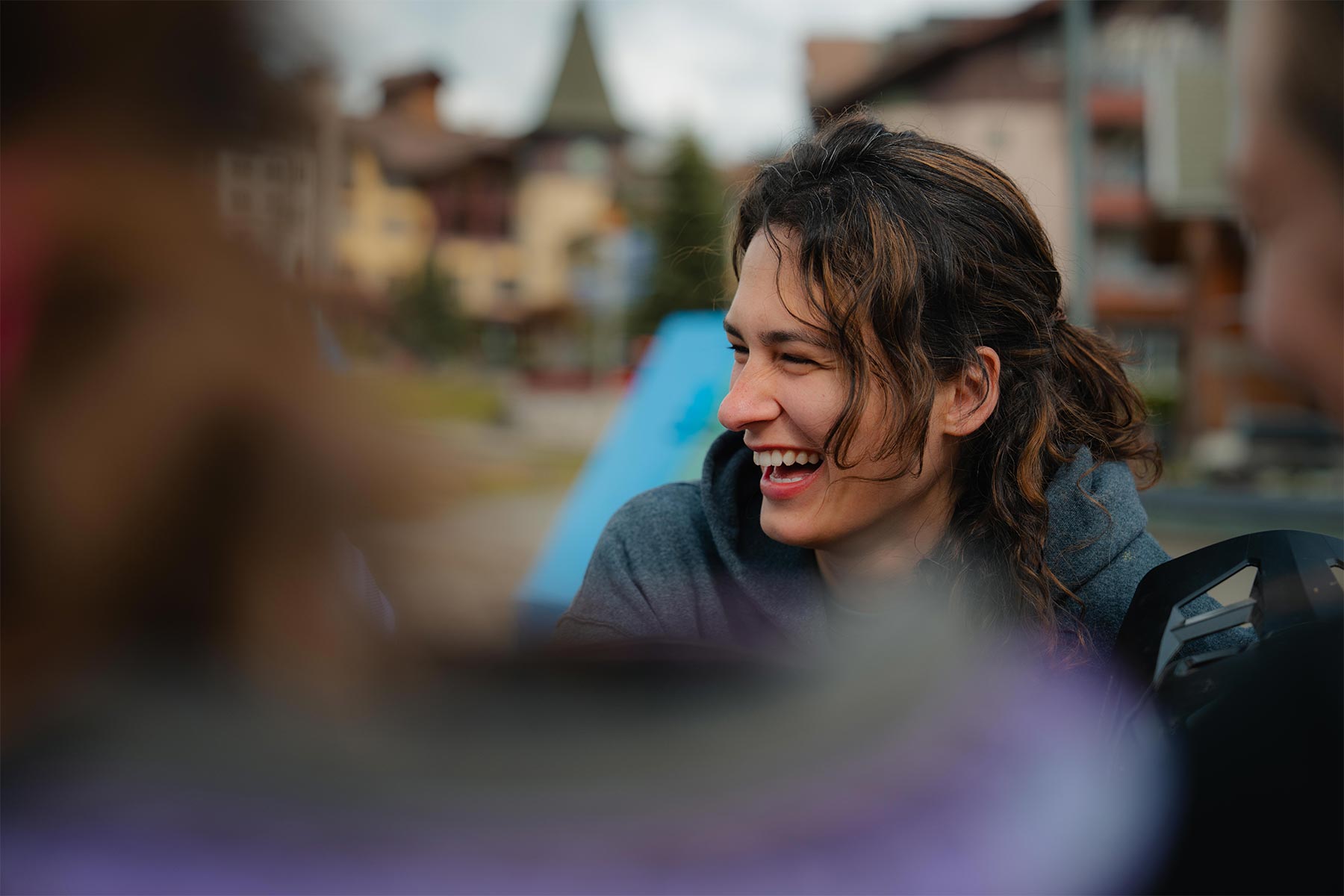 lady laughing with village behind her